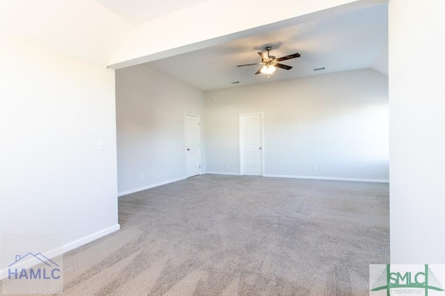 carpeted spare room featuring vaulted ceiling and ceiling fan