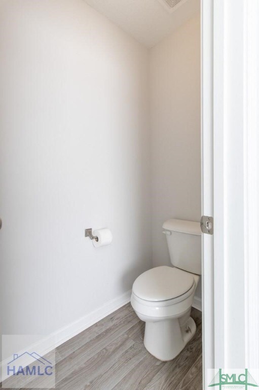 bathroom with toilet and hardwood / wood-style flooring