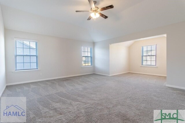 unfurnished room featuring ceiling fan, plenty of natural light, light colored carpet, and lofted ceiling