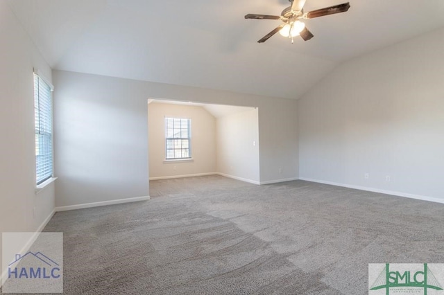 carpeted spare room featuring vaulted ceiling and ceiling fan