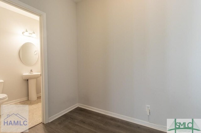 bathroom featuring wood-type flooring and toilet