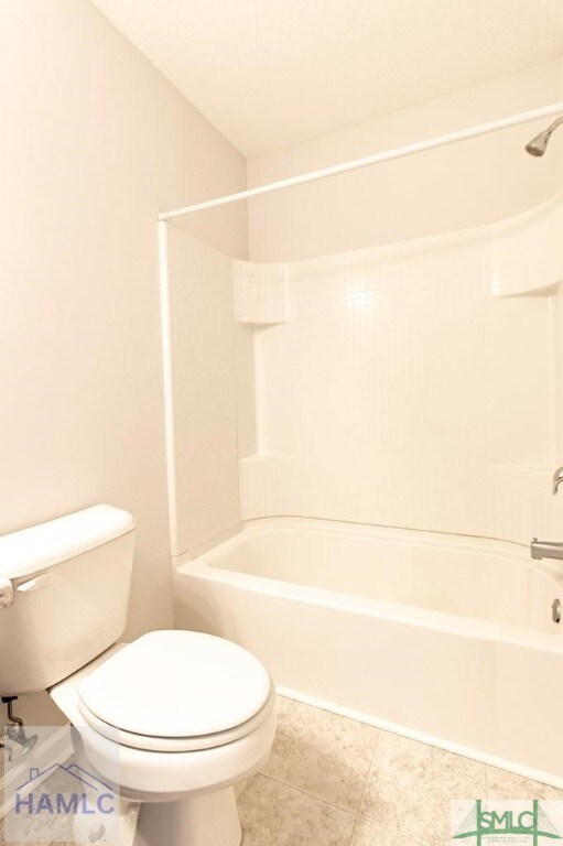 bathroom with shower / washtub combination and toilet