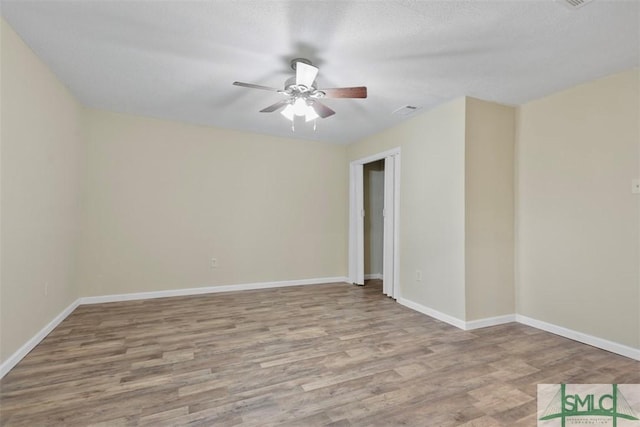 unfurnished room featuring ceiling fan, light hardwood / wood-style floors, and a textured ceiling