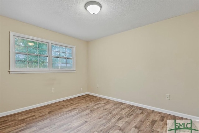 unfurnished room featuring light hardwood / wood-style floors and a textured ceiling