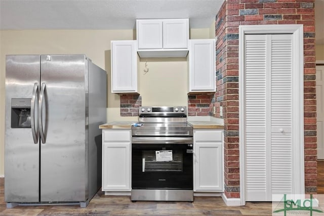 kitchen featuring appliances with stainless steel finishes, white cabinetry, and wood-type flooring