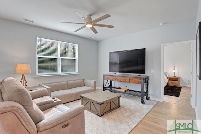 living room featuring light hardwood / wood-style floors and ceiling fan