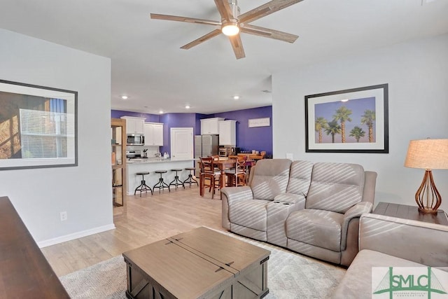 living room with ceiling fan and light wood-type flooring