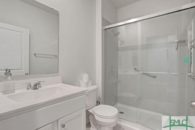 bathroom with vanity, toilet, and a shower with shower door