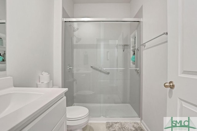 bathroom featuring vanity, toilet, and a shower with door