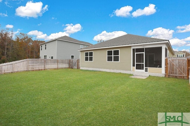 back of property featuring a sunroom and a lawn