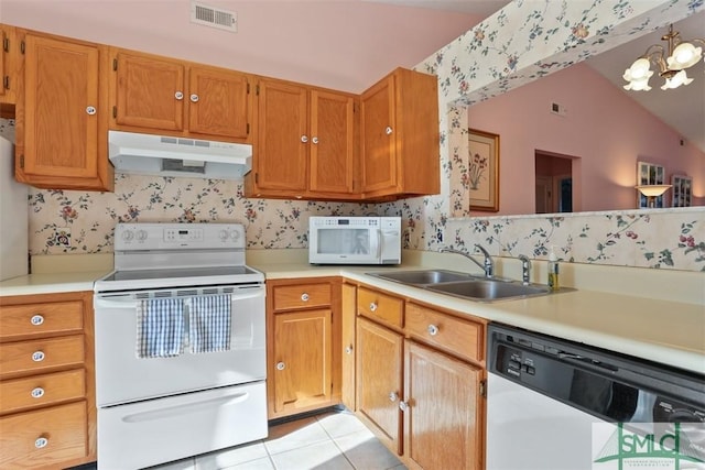 kitchen with sink, white appliances, an inviting chandelier, light tile patterned flooring, and vaulted ceiling