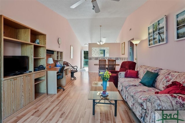 living room with built in desk, lofted ceiling, light wood-type flooring, ceiling fan, and a textured ceiling