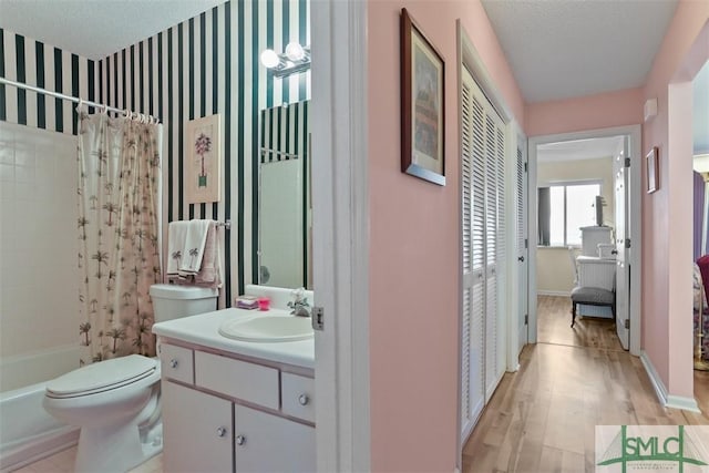 full bathroom featuring vanity, toilet, a textured ceiling, and shower / bath combo