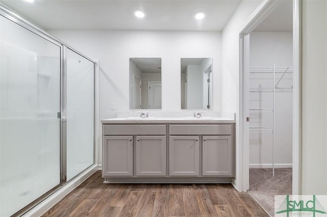 bathroom featuring vanity, hardwood / wood-style flooring, and a shower with door