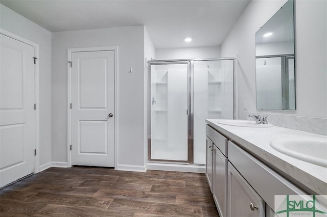 bathroom with hardwood / wood-style floors, vanity, and walk in shower