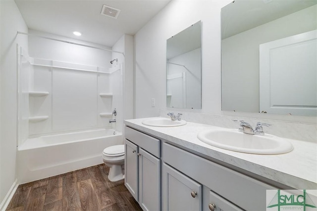 full bathroom featuring vanity, toilet, wood-type flooring, and shower / washtub combination