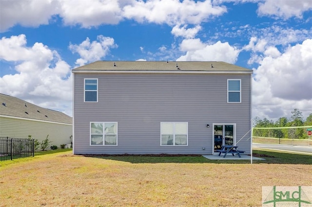 rear view of house with a lawn and a patio