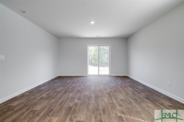 empty room with dark hardwood / wood-style flooring