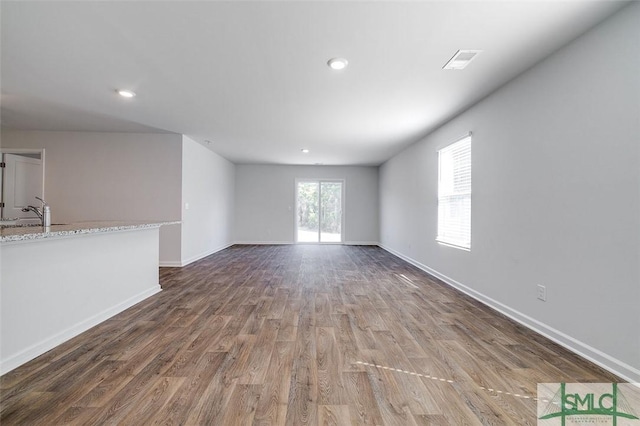 unfurnished living room with sink and dark hardwood / wood-style floors