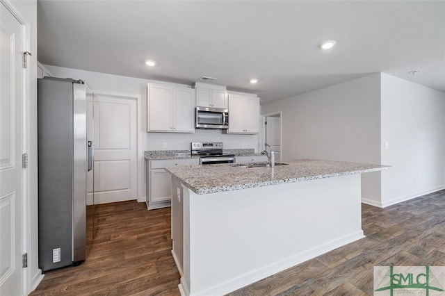 kitchen with sink, dark hardwood / wood-style flooring, a kitchen island with sink, white cabinets, and appliances with stainless steel finishes