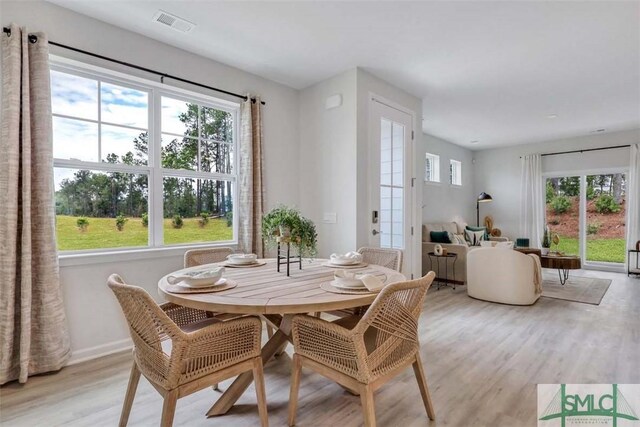 dining space with a wealth of natural light and light hardwood / wood-style flooring