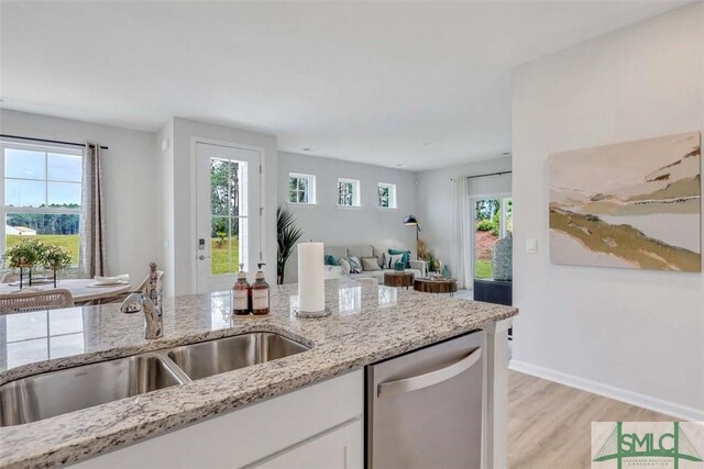 kitchen featuring dishwasher, light wood-type flooring, plenty of natural light, and sink