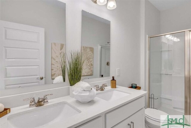 bathroom with vanity, toilet, and a shower with door