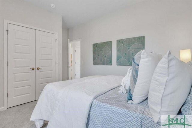 bedroom featuring light carpet and a closet