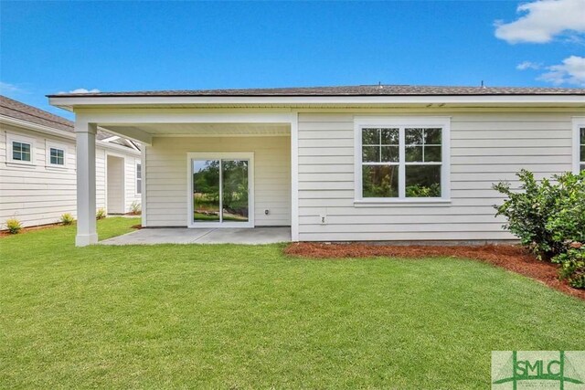 rear view of house with a patio area and a lawn