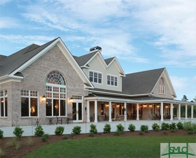 rear view of house with french doors and a lawn