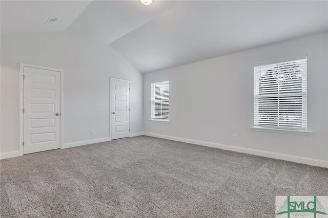 empty room with carpet and vaulted ceiling