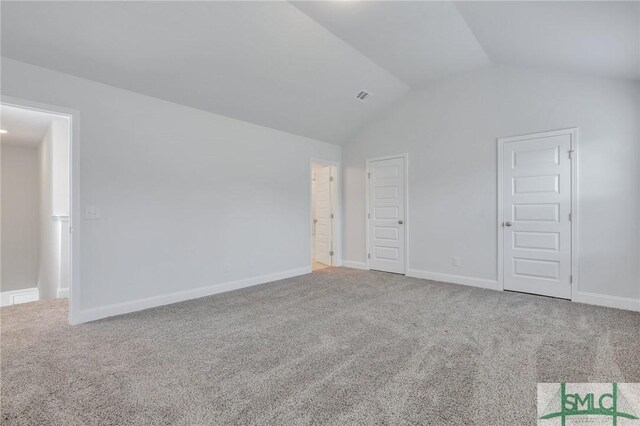 unfurnished bedroom with carpet and vaulted ceiling