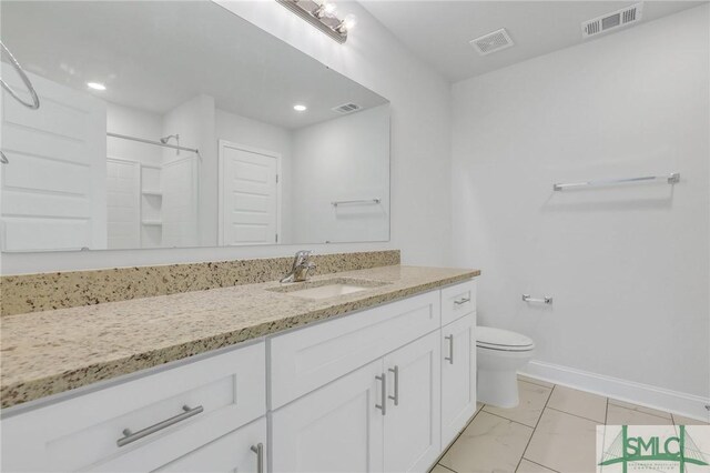 bathroom featuring a shower, vanity, and toilet