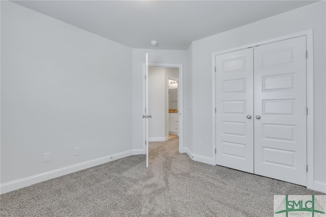 unfurnished bedroom featuring light colored carpet and a closet