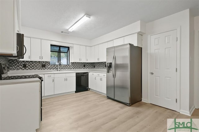 kitchen with sink, white cabinetry, tasteful backsplash, light hardwood / wood-style floors, and black appliances