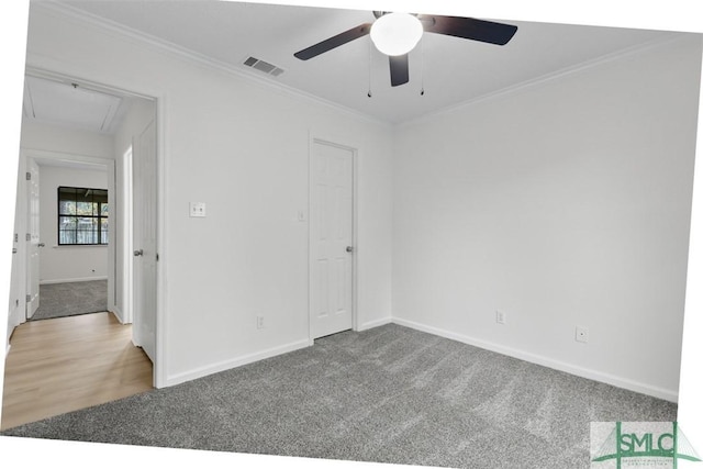 carpeted spare room featuring crown molding and ceiling fan