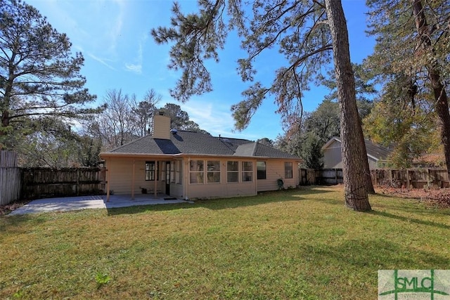 rear view of property with a yard and a patio area