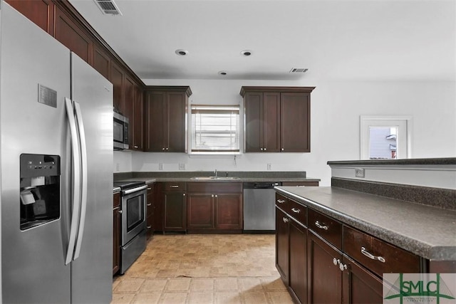 kitchen featuring dark brown cabinetry, sink, and stainless steel appliances