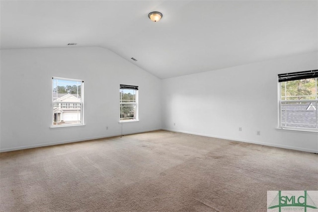 carpeted empty room featuring vaulted ceiling