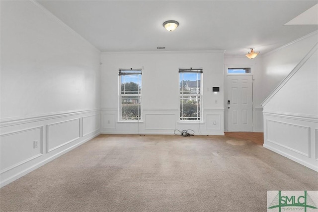 foyer featuring crown molding and carpet floors