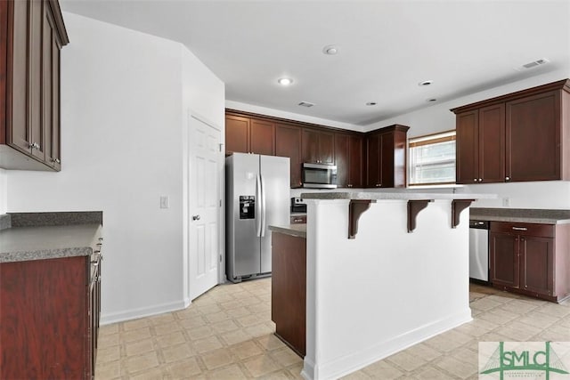 kitchen featuring a kitchen breakfast bar, a center island, and stainless steel appliances