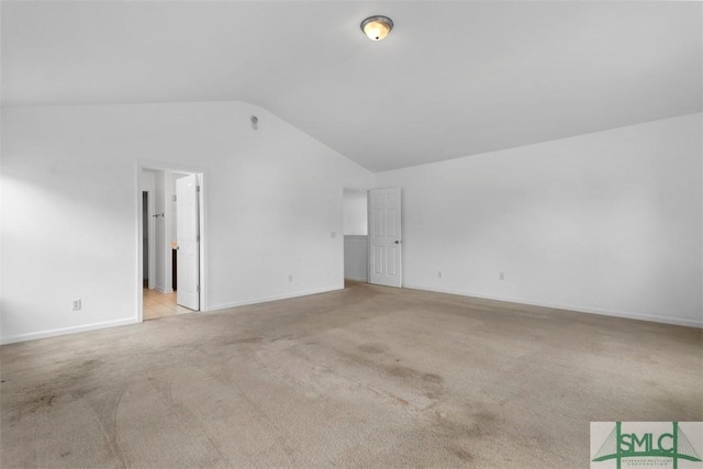 empty room featuring light carpet and vaulted ceiling