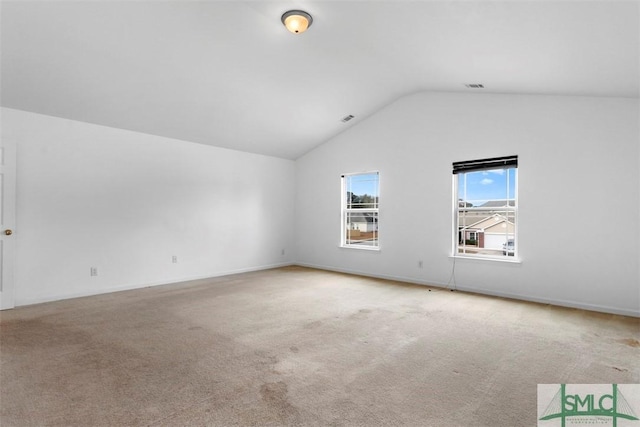 spare room with carpet flooring and vaulted ceiling