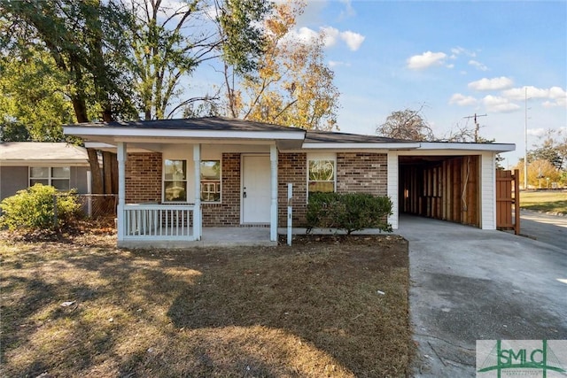 ranch-style home with a porch and a carport