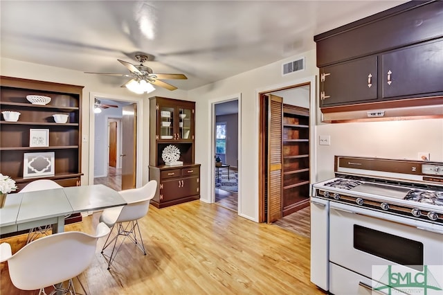 kitchen featuring dark brown cabinets, light hardwood / wood-style floors, ceiling fan, and gas range gas stove