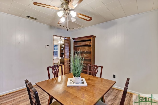 dining space with light hardwood / wood-style floors and crown molding