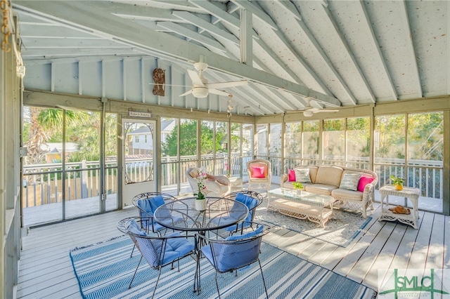 sunroom with vaulted ceiling, a wealth of natural light, and ceiling fan