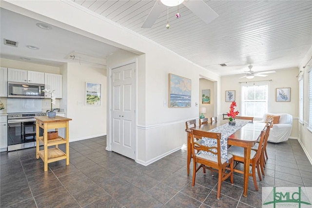 dining area with ceiling fan, dark tile patterned floors, and ornamental molding