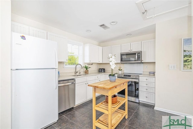 kitchen featuring white cabinets, stainless steel appliances, and sink