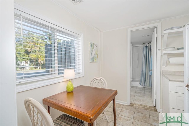 dining space featuring light tile patterned flooring and crown molding